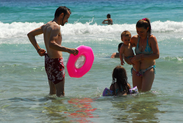 Porodica na plaži sa gumom za kupanje